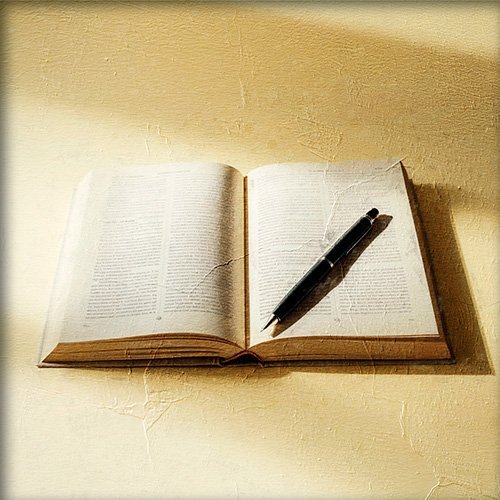 Libro abierto con una pluma encima de el