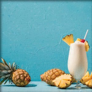 Imagen de una bebida de piña colada con dos piñas en una mesa